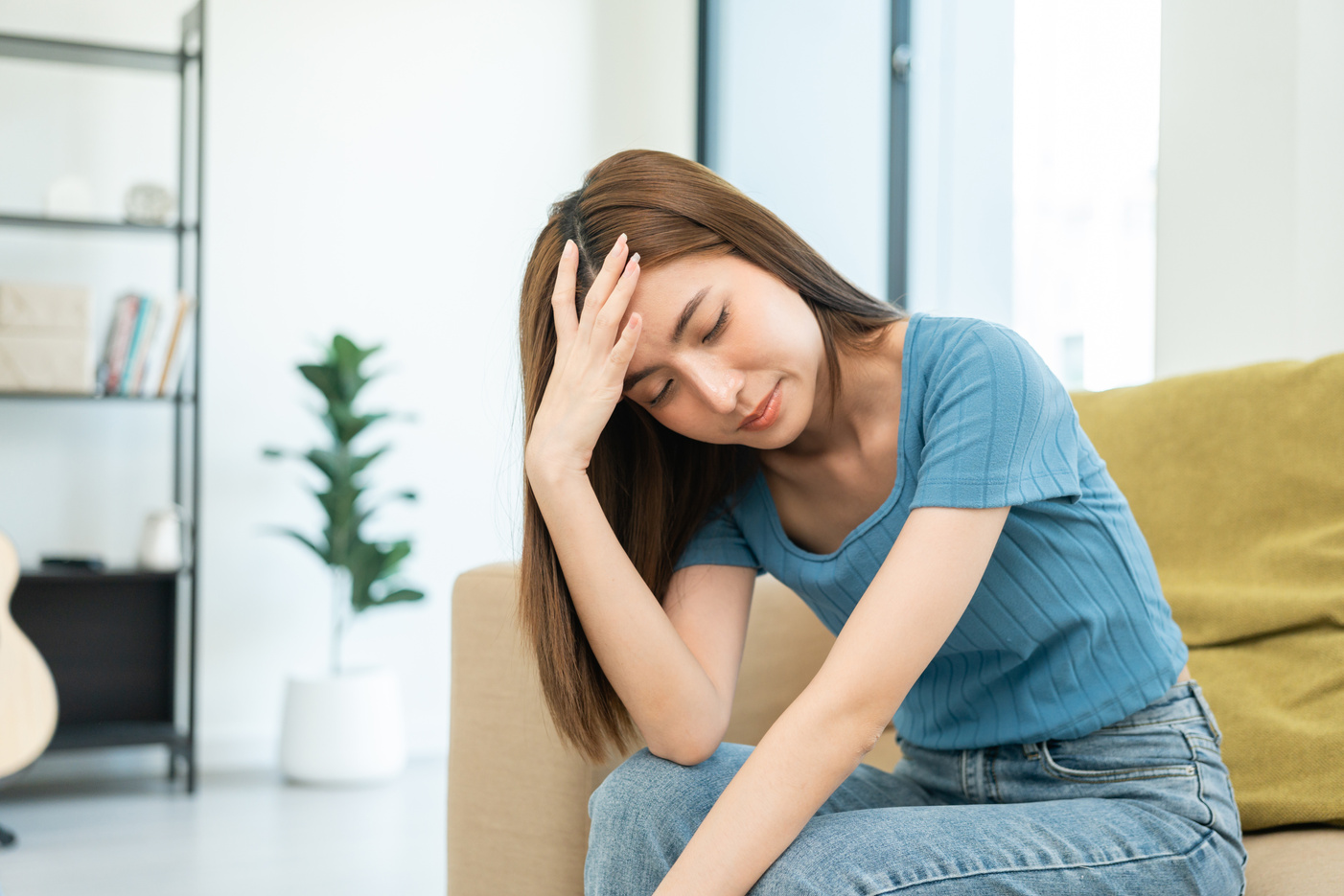 Depressed and Stressed asian woman on sofa. Crying sadness female alone in home problem in life. Unhappy asian woman headache Upset frustrated by problem love relationship feeling despair and anxiety